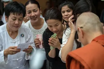 Grupo de mujeres laicas sonriendo frente a un bhikkhu